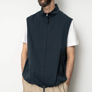 Homme portant le gilet à col montant de Still By Hand en bleu marine, associé à un t-shirt blanc, style moderne pour SS25.