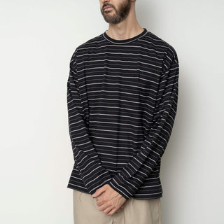 Homme portant un t-shirt à rayures en noir et blanc de Still By Hand, style décontracté de la collection SS25