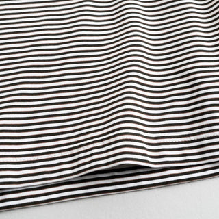 Vue rapprochée des rayures du t-shirt blanc et olive de Still By Hand, collection SS25