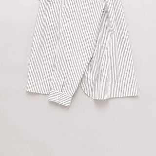 Vue latérale de la chemise oversize rayée blanche de Still By Hand, collection SS25, mettant en évidence les manches.
