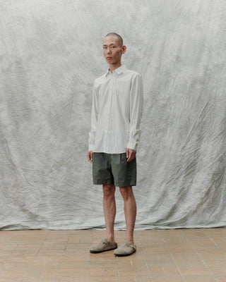 Modèle entier présentant la chemise à rayures en ivoire de Libertine-Libertine avec un fond texturé, SS25.