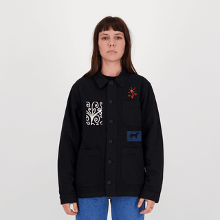 Modèle portant la chemise noire Encré ornée de motifs créatifs, parfaite pour un style contemporain.