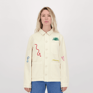 Modèle portant la veste brodée 'Gribouillages' d'Encré, couleur beige avec des motifs brodés en différentes couleurs. Idéale pour ajouter une touche originale à votre tenue.