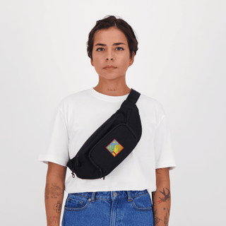 Modèle portant la sacoche banane Encré La dune - Black, en noir, portée en bandoulière sur un t-shirt blanc. Parfaite pour une touche de style avec la marque Encré.