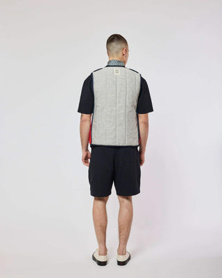 Vue arrière du modèle dans la veste Homecore - Repeat - Navy, soulignant le style tendance de la collection SS25.