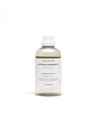 Bouteille de Lessive Hypoallergenic de Steamery, conçue pour les peaux sensibles. Le flacon est transparent, montrant le liquide à l'intérieur, et dispose d'une étiquette indiquant "Hypoallergenic Laundry Detergent" et "Fragrance-Free". Idéal pour un lavage doux et efficace.
