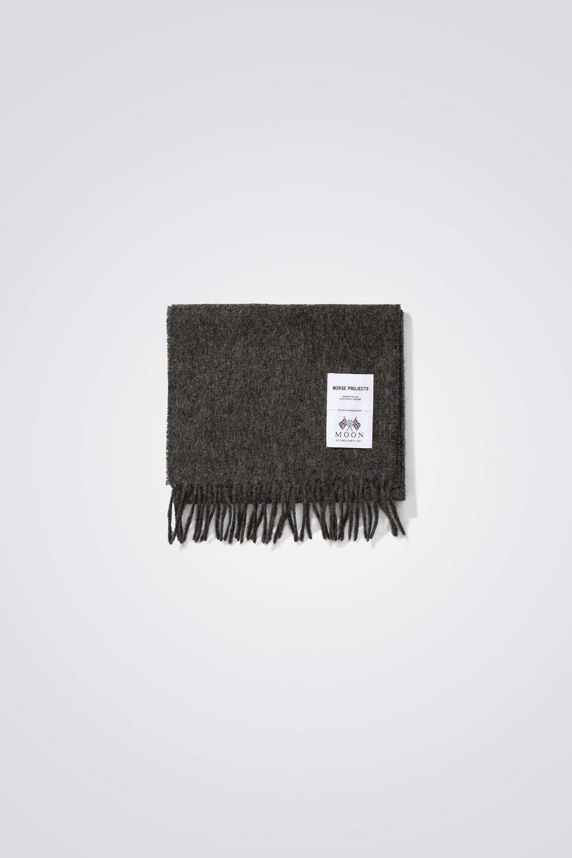Écharpe en laine de mouton mérinos Norse Projects - Moon Merino Lambswool, de couleur charbon, avec étiquette de marque visible et franges décoratives.
