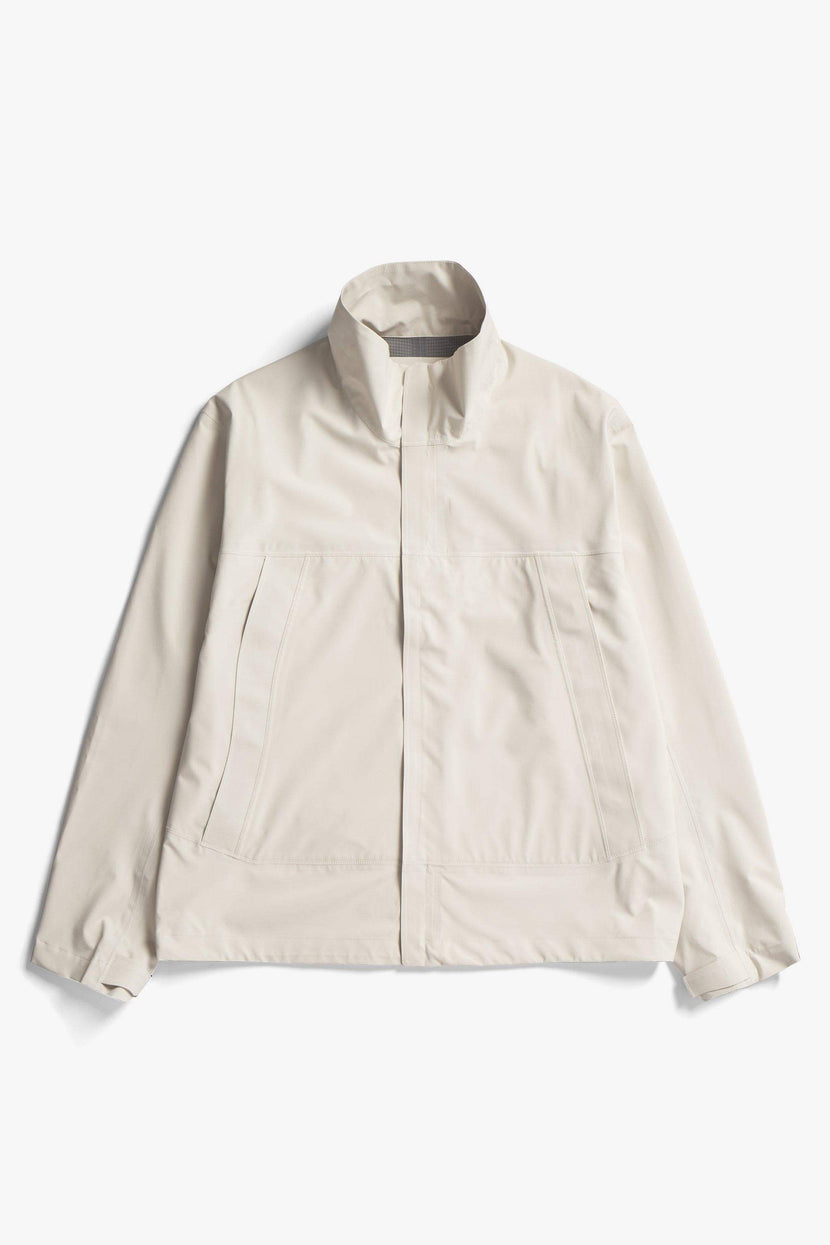 Veste imperméable à col montant 3L Waterproof de Norse Project, couleur blanche, avec fermeture éclair avant et poches latérales.