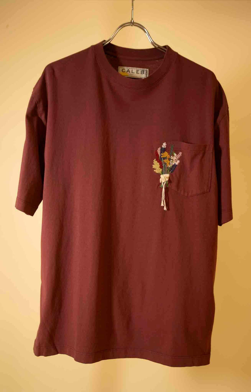T-shirt en jersey bordeaux de Caleb avec une broderie de bouquet coloré sur la poche.
