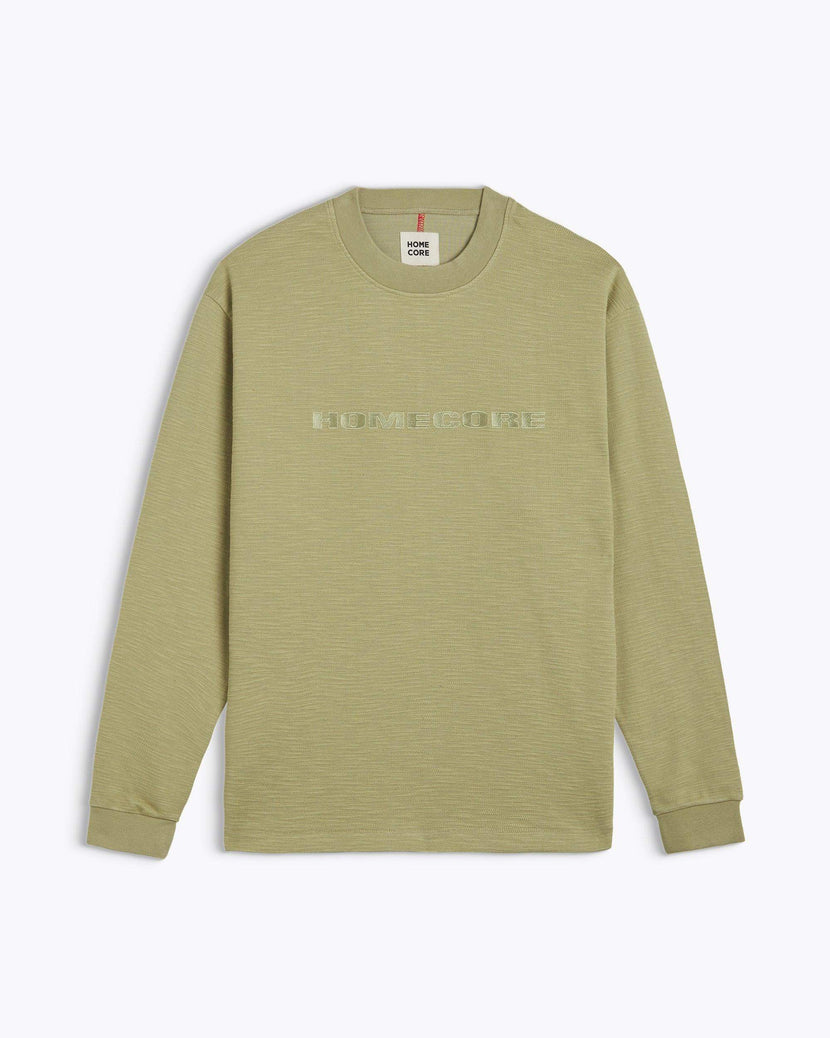 Tee-shirt lourd Earl Graine de Homecore, couleur vert olive, avec logo HOMECORE en relief, parfait pour une tenue décontractée de printemps été 2025 (SS25).