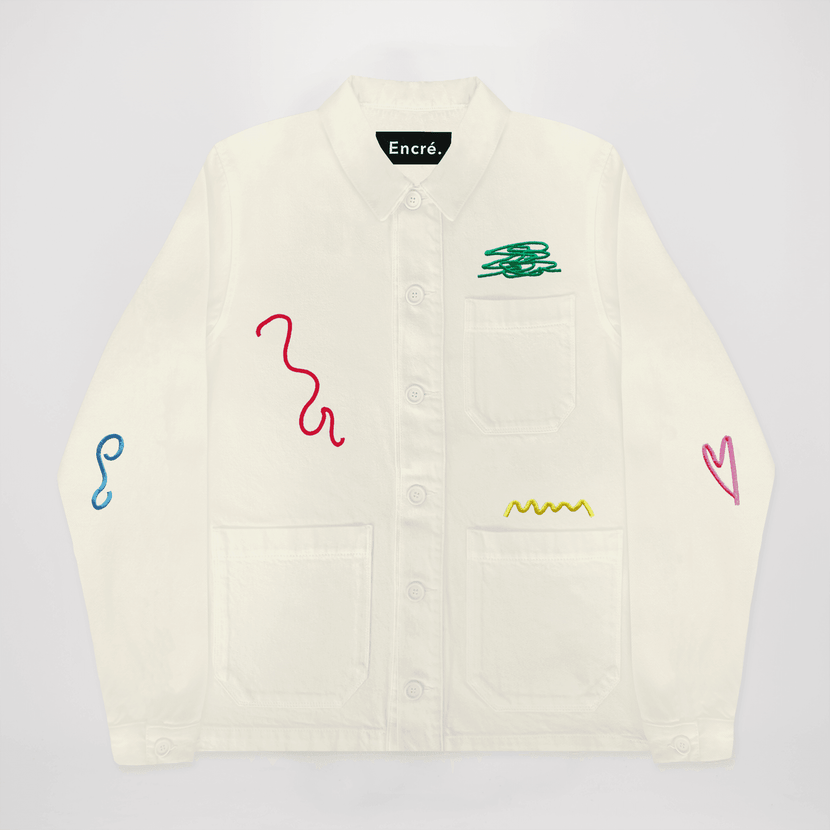 Veste brodée 'Gribouillages' d'Encré en beige, mettant en avant un design graphique avec des broderies colorées. Parfaite pour un style casual.