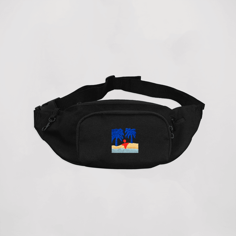 La banane 'La Plage - Black' d'Encré, stylée et pratique, avec un design noir et une broderie colorée de palmiers et d'une plage.