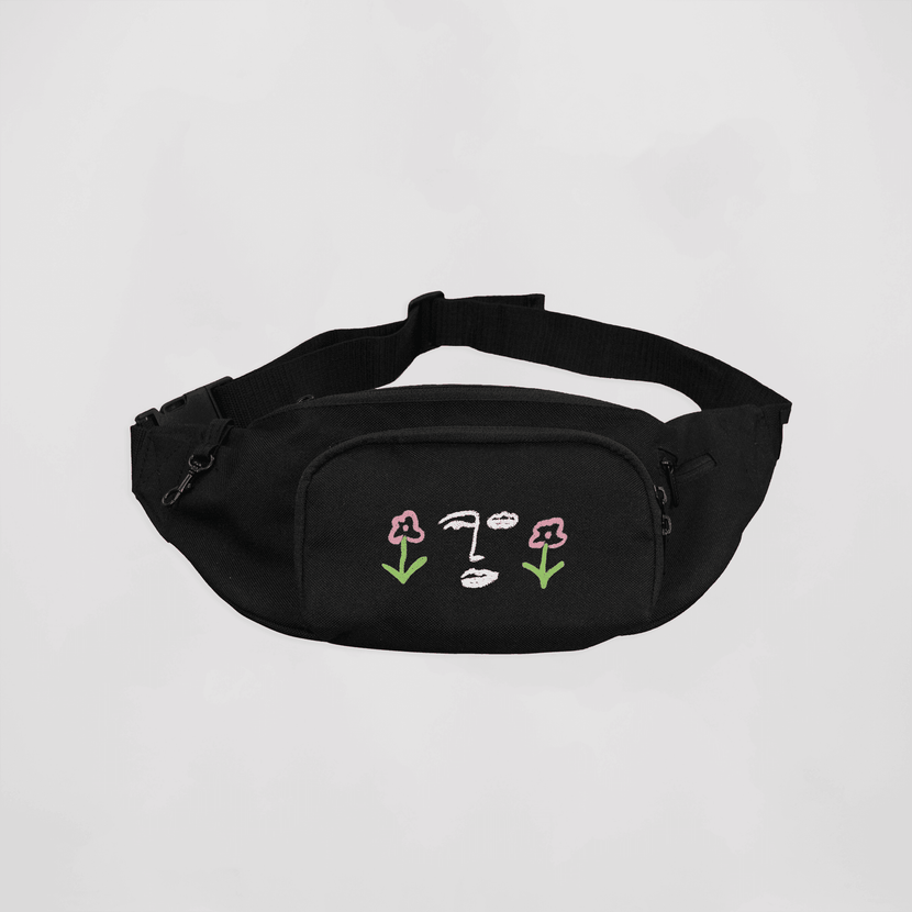 Sacoche banane noire brodée "Le Jardin" de la marque Encré, présentant un design unique avec des fleurs stylisées et un visage embrodé.