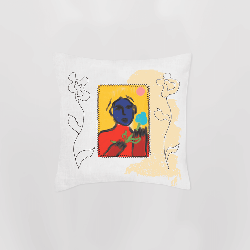 Coussin brodé 'Marceau avait un cadeau' en blanc, conçu par Encré. Ce coussin se distingue par son design coloré avec une illustration d'une figure humaine sur fond jaune et éléments floraux, apportant une touche d'élégance et de confort à l'intérieur.