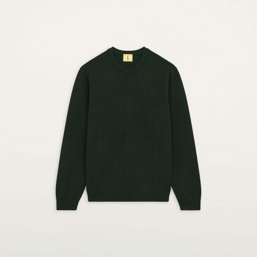 Pull col rond Youri de Nitto Knitwear en couleur vert forêt sur fond neutre.