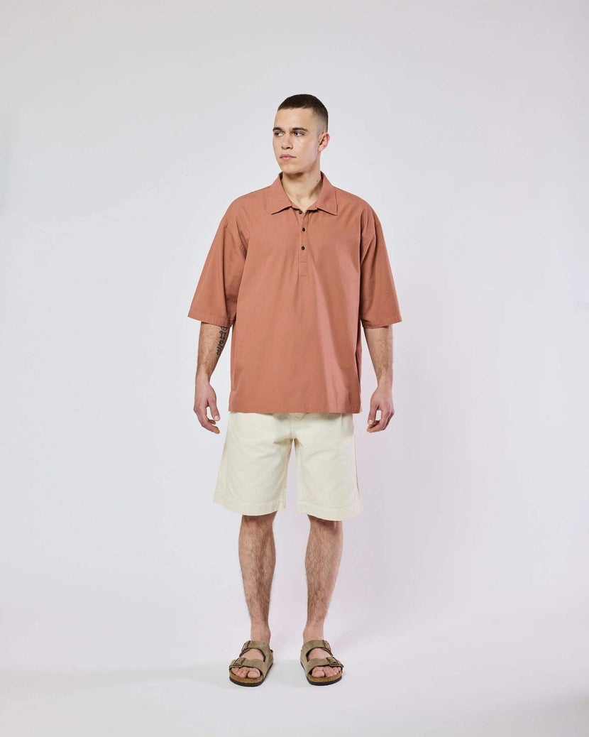 Homme portant la chemise Tony Ripstop en bois de cèdre de Homecore, avec une coupe oversize, des manches courtes et un col classique. Idéale pour un look décontracté.