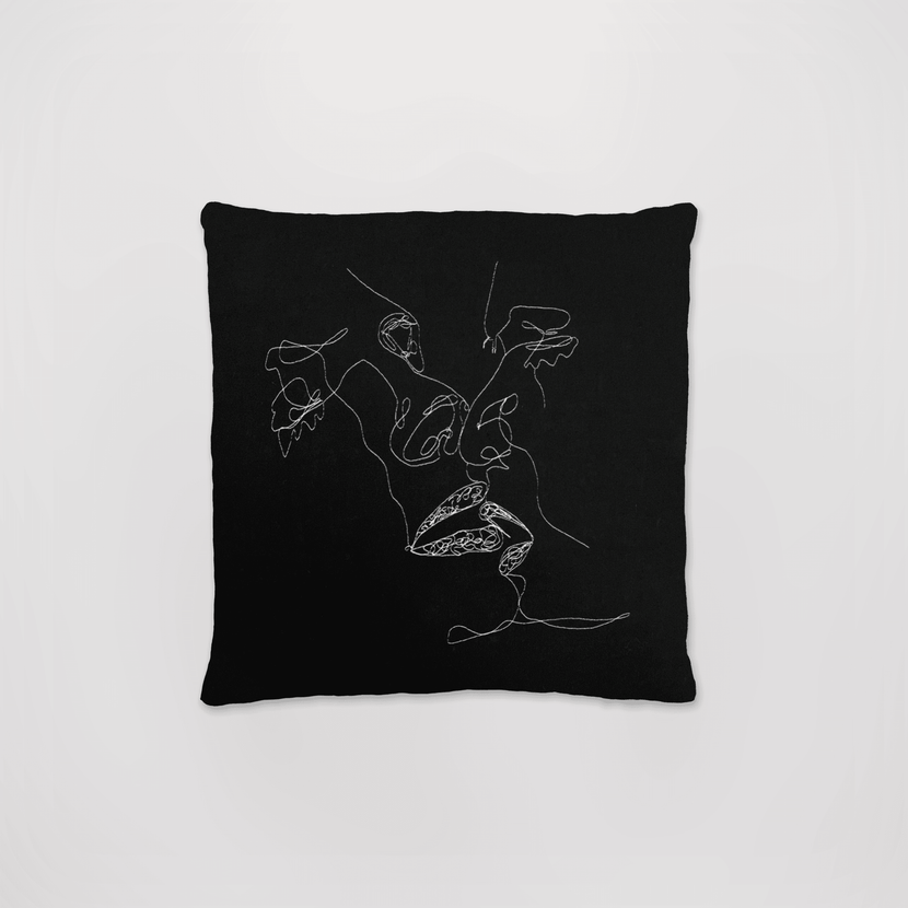 Coussin brodé noir 'L'âme réveuse' de la marque Encré, avec un design artistique minimaliste en fil blanc sur fond noir.