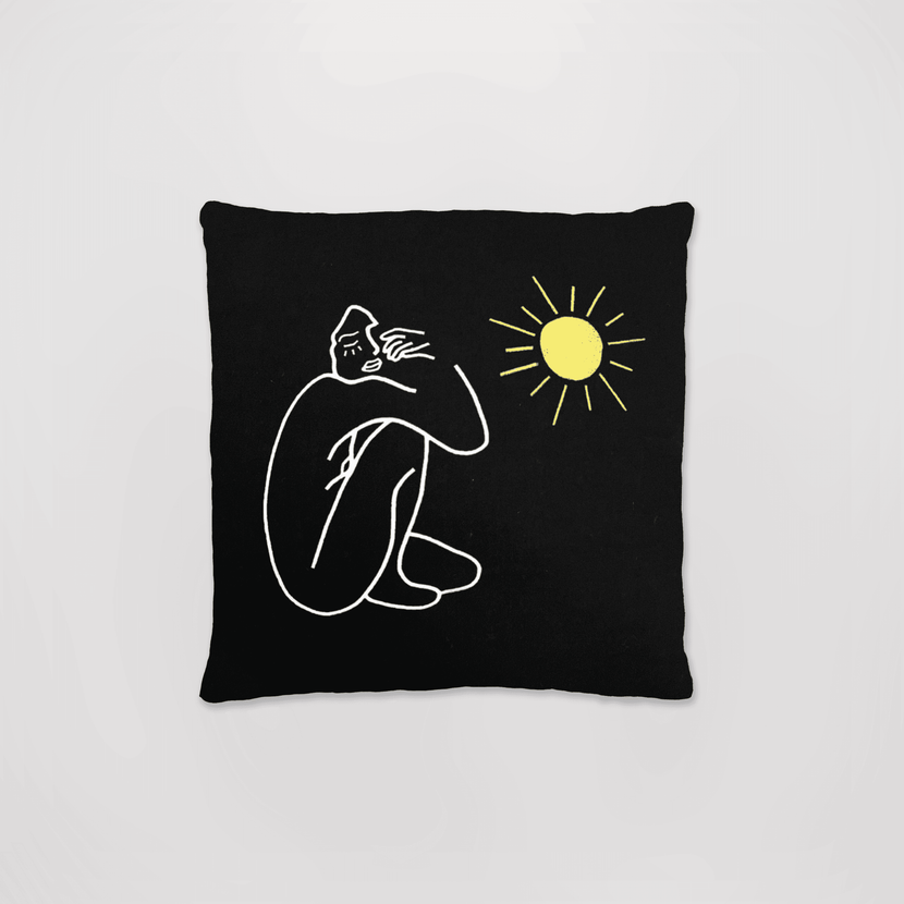 Coussin Sunblessed - Noir de la marque Encré, avec un design minimaliste de silhouette assise et un soleil lumineux sur fond noir.