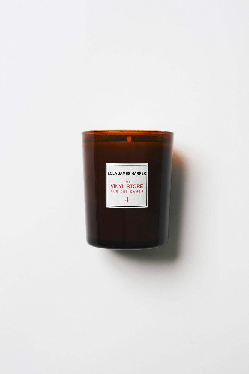 Bougie parfumée de Lola James Harper, intitulée '4. Vinyl store - 190g', présentée dans un verre opaque brun. L'étiquette est blanche avec des inscriptions rouges pour le titre et le nom du vendeur. Idéale pour créer une ambiance chaleureuse.